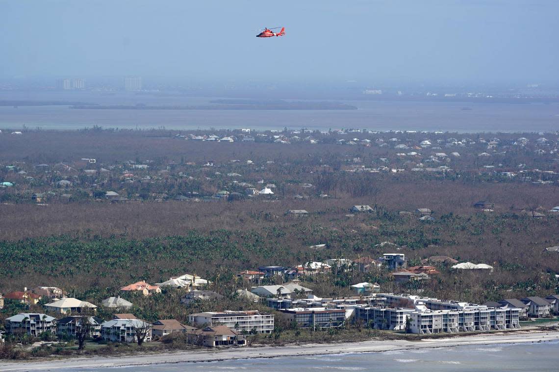 A U.S. Coast Guard HH-65 Dolphin helicopter flies over damaged homes and buildings in the aftermath of Hurricane Ian, Thursday, Sept. 29, 2022, on Sanibel Island, Fla. (AP Photo/Wilfredo Lee)