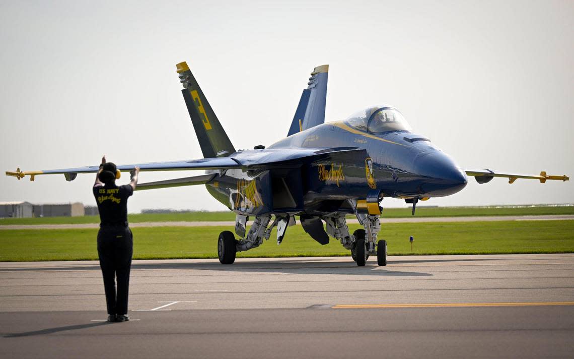 A member of the ground crew for the U.S. Navy Blue Angels guides in the F/A-18E/F Super Hornet piloted by Lt. Amanda Lee,.