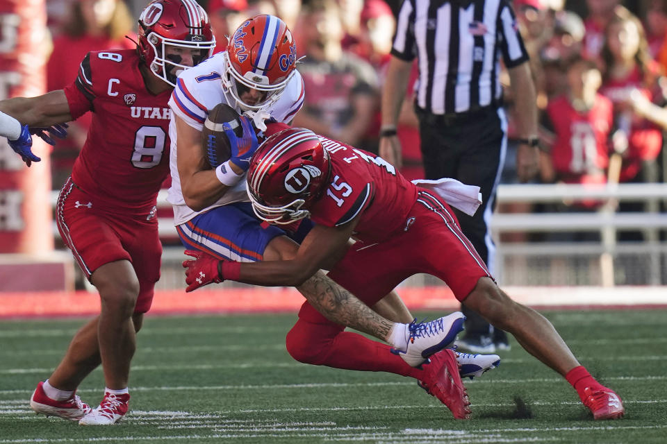 Utah cornerback Tao Johnson (15) tackles Florida wide receiver Ricky Pearsall (1) during the first half of an NCAA college football game Thursday, Aug. 31, 2023, in Salt Lake City. (AP Photo/Rick Bowmer)