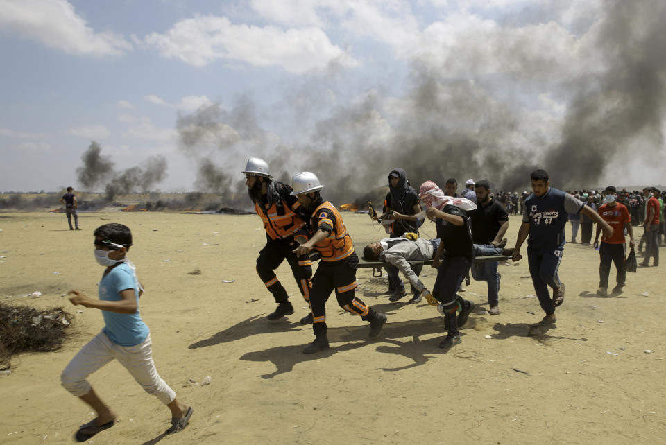 Palestinian medics and protesters evacuate a wounded youth during a protest at the Gaza Strip’s border with Israel, east of Khan Younis, Gaza Strip, Monday, May 14, 2018 (AP Photo/Adel Hana)