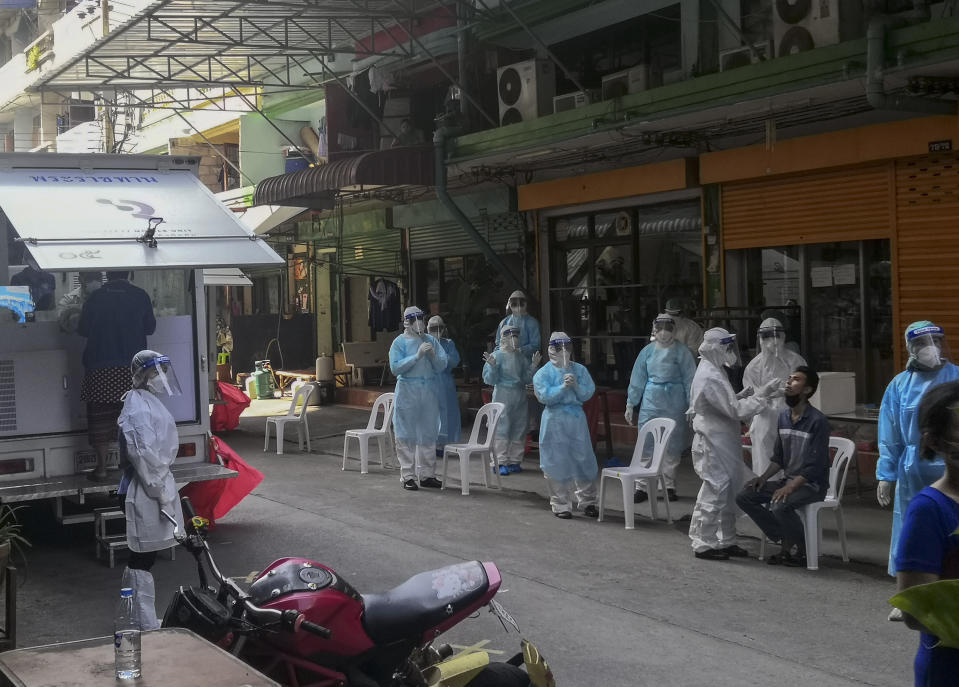 A health worker in protective clothing collects nasal swab sample from a man to test for COVID-19 in Samut Sakhon, South of Bangkok, Thailand, Sunday, Dec. 20, 2020. Thailand reported more than 500 new coronavirus cases on Saturday, the highest daily tally in a country that had largely brought the pandemic under control. (AP Photo/ Chalida Ekvitthayavechnukul)