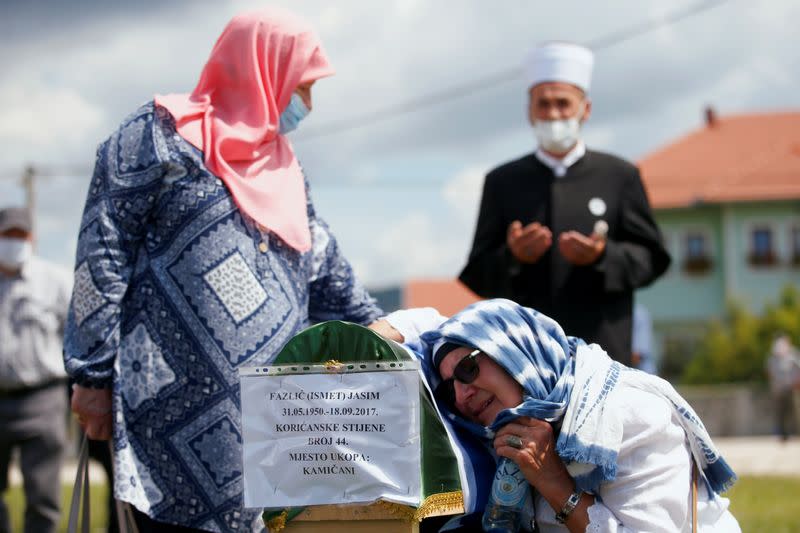 Bosnian Muslims attend a collective funeral in Kamicani