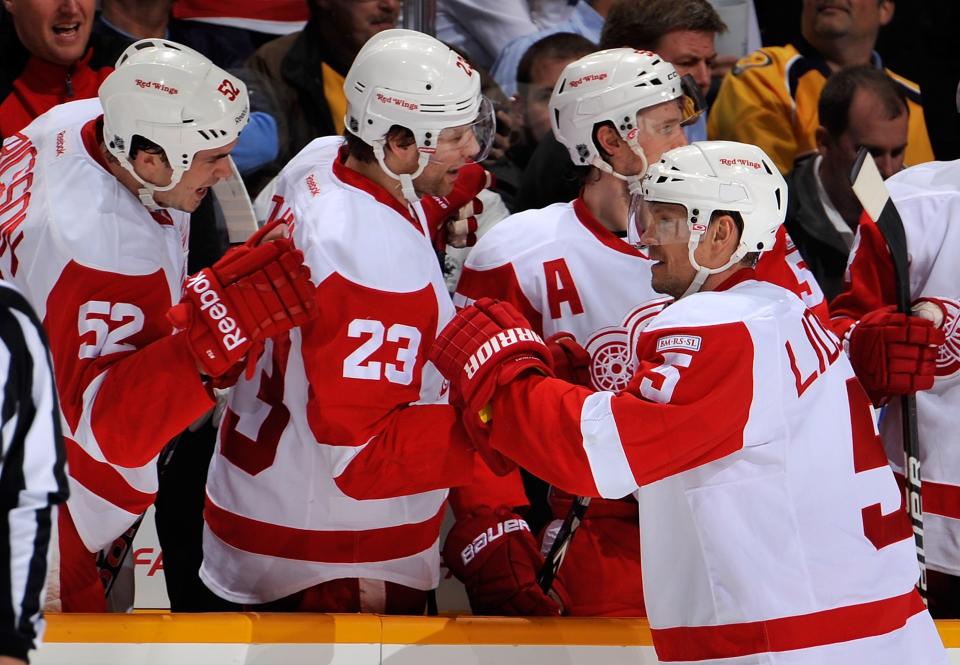 NASHVILLE, TN - DECEMBER 15: Jonathan Ericsson #53 and Brad Stuart #23 of the Detroit Red Wings congratulate teammate Nicklas Lidstrom #5 on scoring a goal against the Nashville Predators at the Bridgestone Arena on December 15, 2011 in Nashville, Tennessee. (Photo by Frederick Breedon/Getty Images)