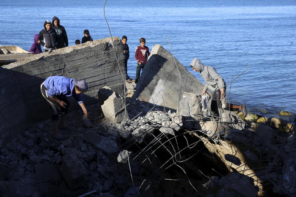 Residents inspect destroyed sewage pipes following overnight Israeli missile strikes along the beach of Shati refugee camp, in Gaza City, Thursday, Feb. 6, 2020. Earlier on Wednesday, Israel struck Hamas militant targets in Gaza in response to rocket fire toward Israeli communities the previous night. (AP Photo/Adel Hana)