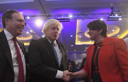 Democratic Unionist Party (DUP) leader Arlene Foster shakes hands with Conservative MP Boris Johnson as Deputy Leader Nigel Dodds looks on, at the DUP annual party conference in Belfast, Northern Ireland November 24, 2018. REUTERS/Clodagh Kilcoyne