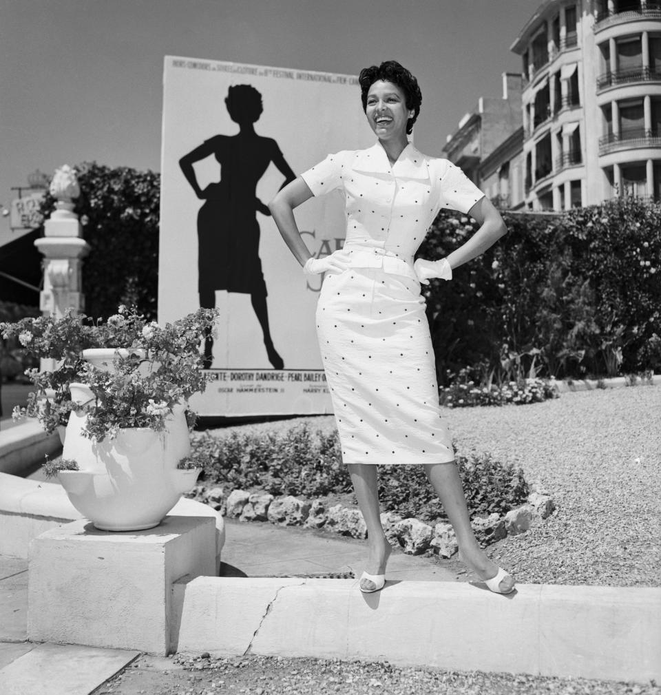 Dandridge poses in front of a poster for her movie "Carmen Jones" in 1955 at the Cannes Film Festival in France.