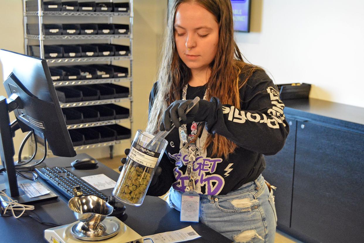 High Profile Shift Lead Sierra Lutz prepares an online order prior to the marijuana dispenary's opening Tuesday at 1500 Interstate 70 Drive SW for the first day of recreational sales in Columbia. She is weighing out a product named Elevate. 