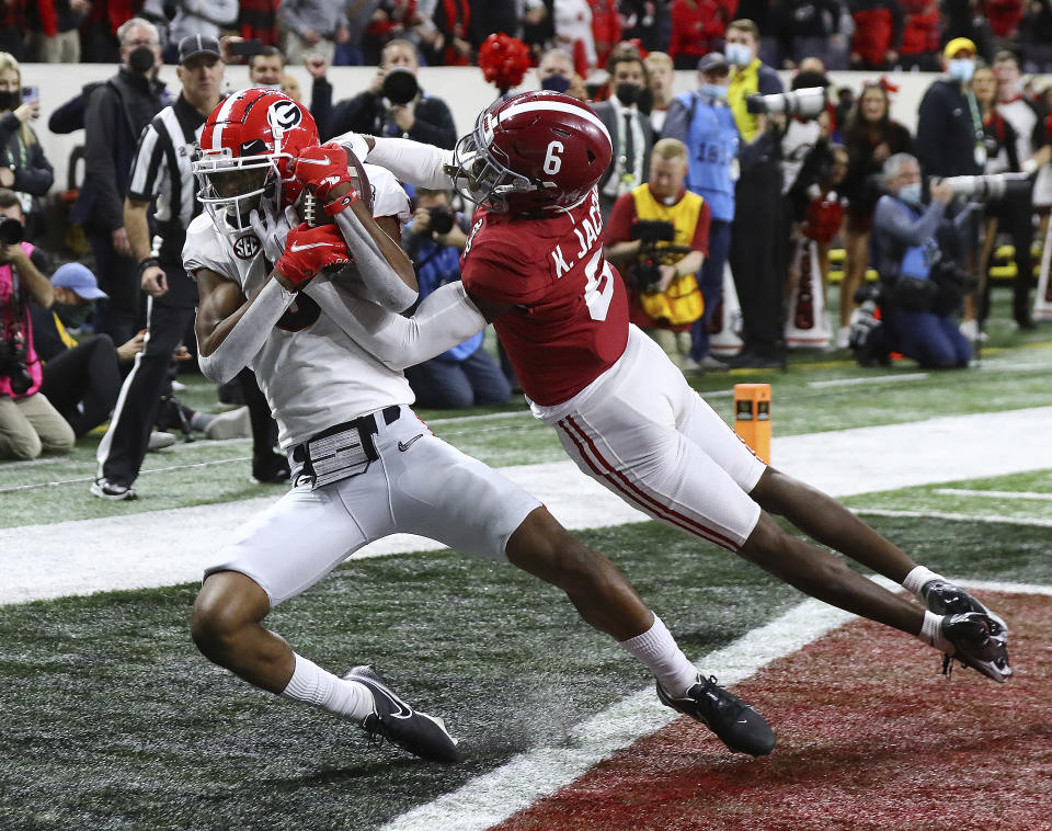 FILE - Georgia wide receiver Adonai Mitchell, left, catches the go-ahead touchdown against Alabama defensive back Khyree Jackson (6) to take a 19-18 lead in the fourth quarter of the College Football Playoff championship football game Jan. 10, 2022, in Indianapolis. Mitchell transferred to Texas shortly after Georgia's championship game win over TCU last season and is now a key part of the Longhorns offense. (Curtis Compton/Atlanta Journal-Constitution via AP, File)