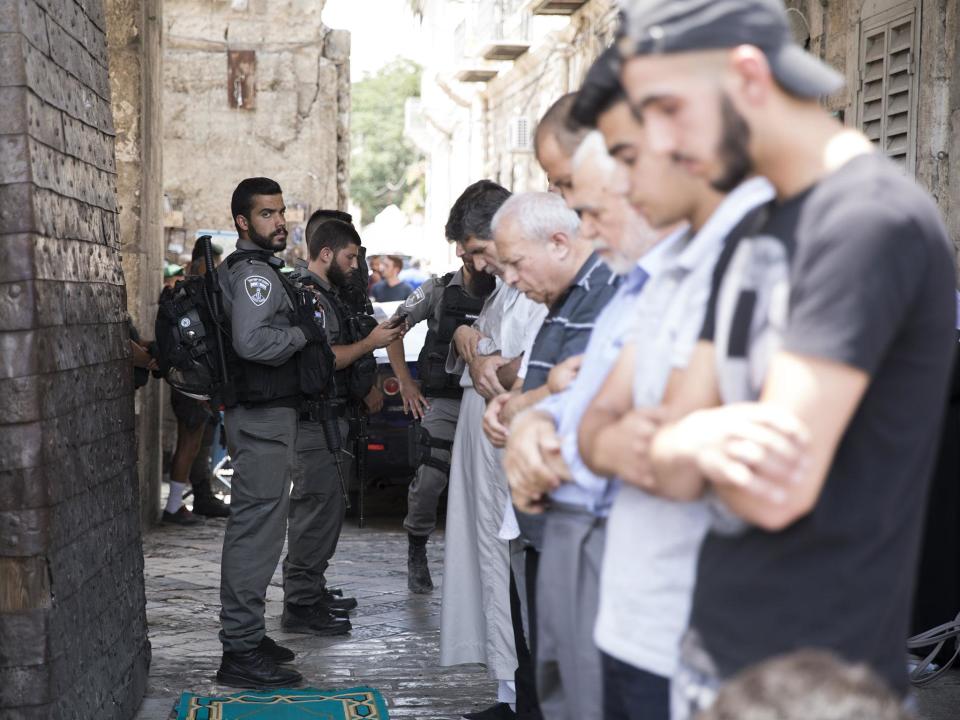 Israeli border police on duty as Palestinians pray at the Lion's Gate in the Old City of Jerusalem near the entrance to the Noble Sanctuary or Temple Mount, at the Old City of Jerusalem: EPA/ABIR SULTAN