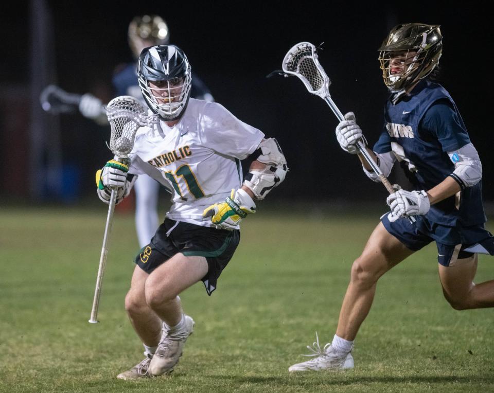 Andrew Frosch (11) controls the ball during the Gulf Breeze vs Catholic boys lacrosse game at Pensacola Catholic High School on Friday, March 31, 2023.