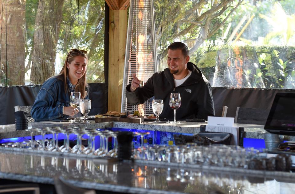 Alexis Kozlilk (left) and her friend Ryan Gagne, of Hobe Sound, enjoying some wine and cheese at the Kork Restaurant patio on Tuesday, Feb. 2, 2021, in Hobe Sound. "This is just an awesome place to come to and grab a nice glass of wine and enjoy some cheese or just have a nice evening with your significant other or friend," Gagne said.  