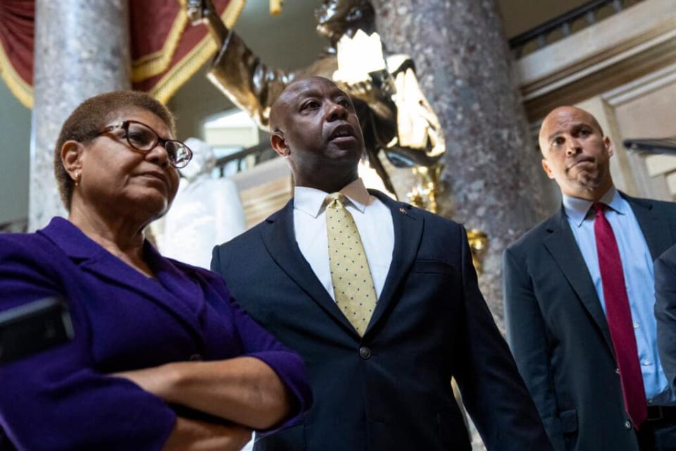 (L-R) Rep. Karen Bass (D-CA), Sen. Tim Scott (R-SC), and Sen. Cory Booker (D-NJ) speak briefly to reporters as they exit the office of Rep. James Clyburn (D-SC) following a meeting about police reform legislation on Capitol Hill May 18, 2021 in Washington, DC. (Photo by Drew Angerer/Getty Images)