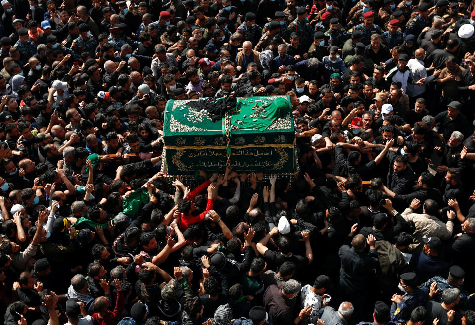 Shiite worshippers carry a symbolic coffin at the golden-domed shrine of Imam Moussa al-Kadhim, who died at the end of the 8th century, during the annual commemoration of his death, in Baghdad, Iraq, Wednesday, March 10, 2021. (AP Photo/Hadi Mizban)