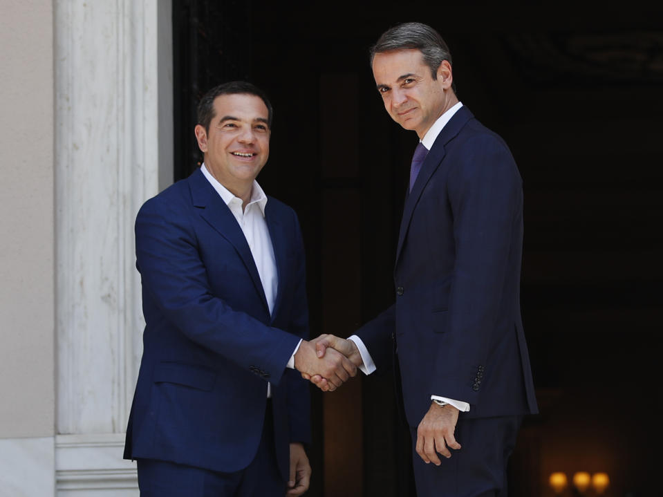 Greece's newly-elected prime minister Kyriakos Mitsotakis, right, is welcomed by former prime minister Alexis Tsipras, left, at Maximos Mansion in Athens, Monday, July 8, 2019. Mitsotakis' New Democracy party won 39.8% of the vote, giving him 158 seats in the 300-member parliament, a comfortable governing majority. (AP Photo/Thanassis Stavrakis)