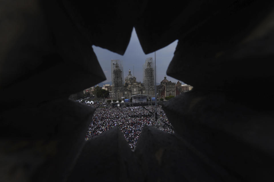 People are seen through a wall as they gather at the capital's main square, the Zócalo, to listen to Mexican President Andrés Manuel López Obrador in Mexico City, Sunday, November 27, 2022. (AP Photo / Marco Ugarte)