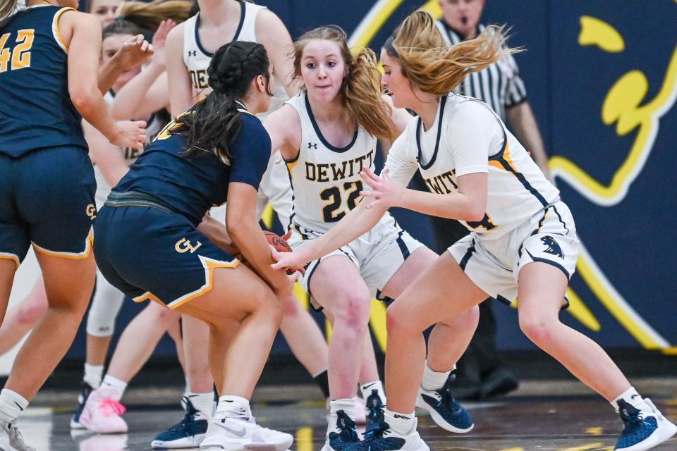 DeWitt's Madison Uyl, center, and Tara Kurncz, right, pressure Grand Ledge's Gianna Naccarato during the fourth quarter on Friday, Feb. 3, 2023, at DeWitt High School.