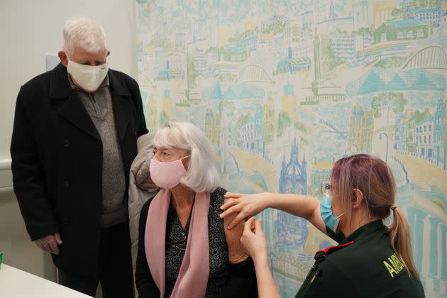 Leonora Deakin (centre), 79, accompanied by James Deakin, 80, receives an injection of the Oxford/Astrazeneca coronavirus vaccine from Hart paramedic Angela Arnot, at a coronavirus vaccination clinic at the NHS Nightingale Hospital North East in Sunderland