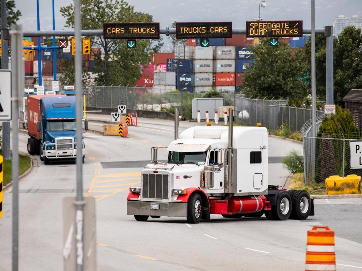 Container transport trucks are seen at the entrance to the Port of Vancouver on May 29, 2019.  (Ben Nelms/CBC - image credit)