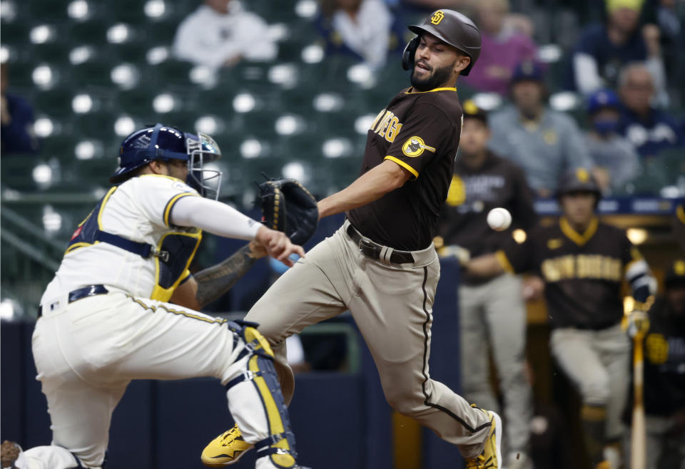 San Diego Padres first baseman Eric Hosmer (30) is tagged out by Milwaukee Brewers Milwaukee Brewers catcher Omar Narvaez (10) during the eighth inning of a baseball game Thursday, May 27, 2021, in Milwaukee. (AP Photo/Jeffrey Phelps)