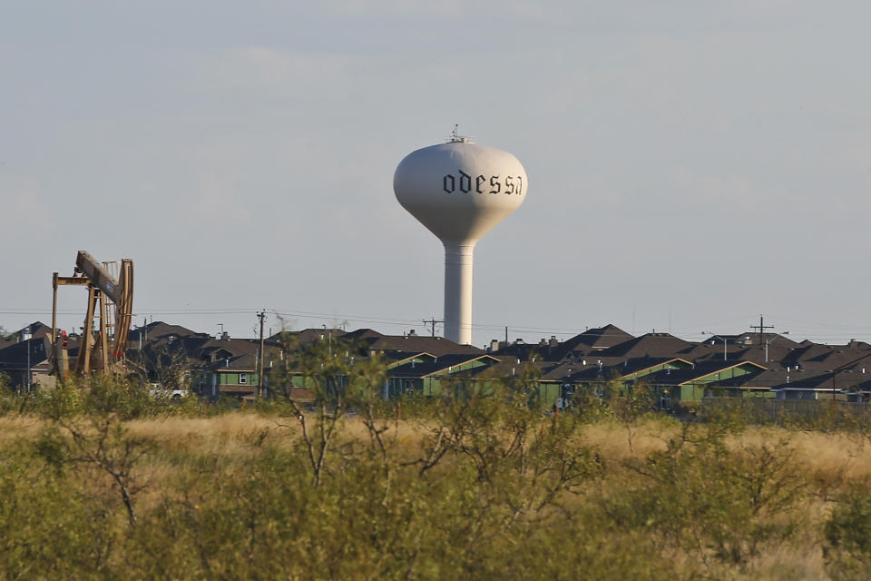 In this Monday, Sept. 2, 2019, photo, a water tower stands in a neighborhood with a near-by pump jack in Odessa, Texas. Odessa, in the Permian Basin region, is known for its oil fields that cut into neighborhoods where a boom cycle has made housing expensive and scarce. (AP Photo/Sue Ogrocki)