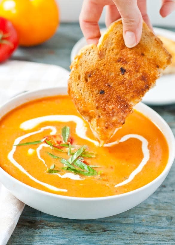 bread being dipped into the bowl of soup