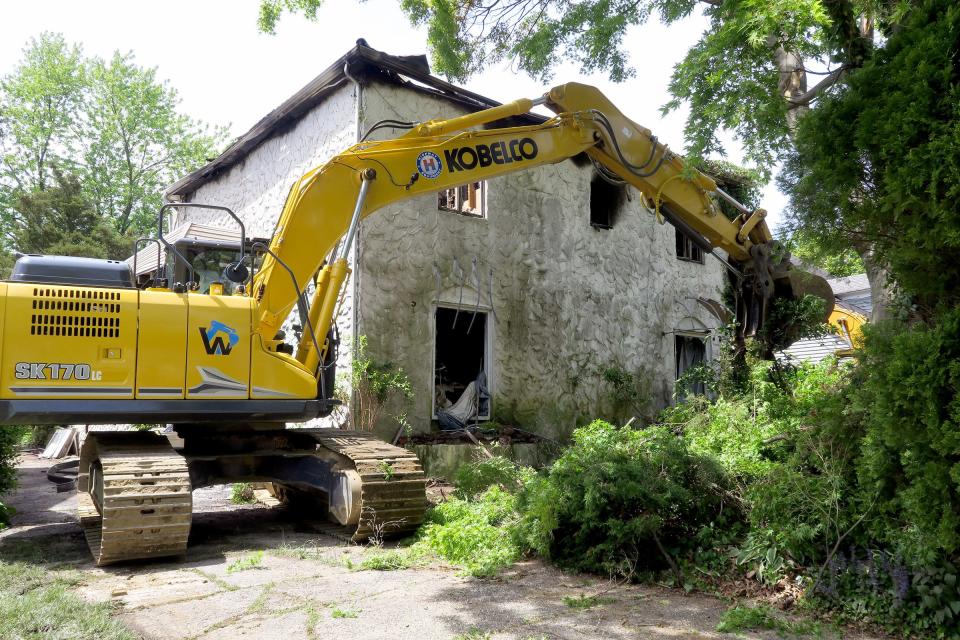 Trees and brush are cleared from a home at 419 Morris Ave. in Spring Lake Saturday, May 11. An elderly resident escaped the early morning fire.