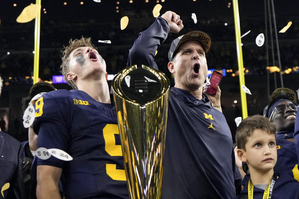 Michigan head coach Jim Harbaugh and quarterback J.J. McCarthy celebrate with the trophy after their win against Washington in the national championship NCAA College Football Playoff game Monday, Jan. 8, 2024, in Houston. (AP Photo/David J. Phillip)