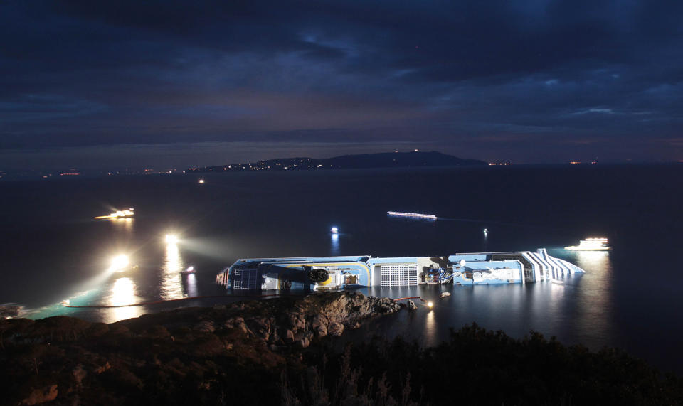 FILE - In this Monday, Jan. 16, 2012 file photo, The cruise ship Costa Concordia leans on its side after running aground near the tiny Tuscan island of Giglio, Italy. As if the nightmares, flashbacks and anxiety weren't enough, passengers who survived the terrifying grounding and capsizing of the Costa Concordia off Tuscany have come in for a rude shock as they mark the first anniversary of the disaster on Sunday, Jan. 13, 2013. Ship owner Costa Crociere SpA, the Italian unit of Miami-based Carnival Corp., sent several passengers a letter telling them they weren't welcome at the official anniversary ceremonies on the island of Giglio where the hulking ship still rests. Costa says the day is focused on the families of the 32 people who died Jan. 13, 2012, not the 4,200 passengers and crew who survived. (AP Photo/Gregorio Borgia, File)