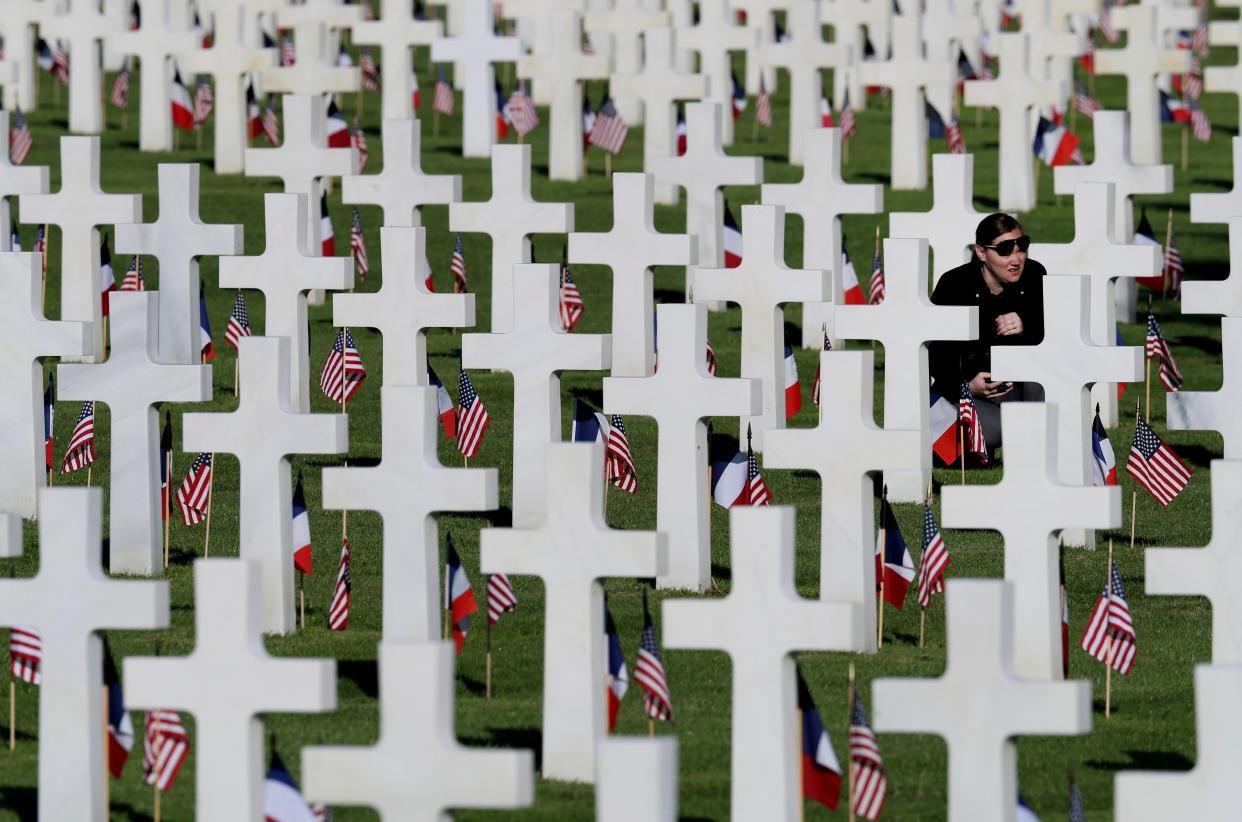 A young woman visits headstones of World War II soldiers prior to a ceremony to mark the 75th anniversary of D-Day at the Normandy American Cemetery in Colleville-sur-Mer, Normandy, France, on June 6, 2019. World leaders gathered in France to mark the 75th anniversary of the D-Day invasion that helped liberate Europe from Nazi Germany.