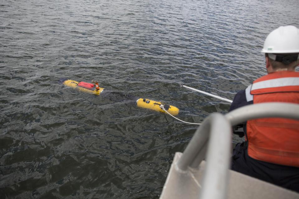 Ben Pelletier, marine operations engineer for Bluefin Robotics, attempts to retrieve a submarine in Quincy, Mass., Wednesday, April 9, 2014. Bluefin Robotics shipped a version of their submarine to help locate the missing Malaysian Airlines Flight 370, by using its side-scan sonar. (AP Photo/Scott Eisen)