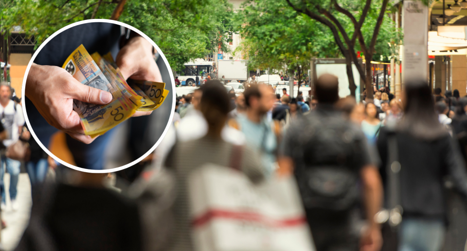 Insert of man holding Australian cash with shoppers walking on street