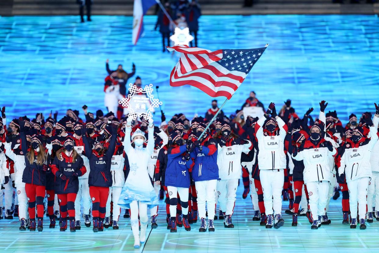 Flag bearers Brittany Bowe and John Shuster of Team United States carry their flag during the Opening Ceremony of the Beijing 2022 Winter Olympics