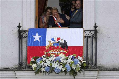 Chile's new president Michelle Bachelet (C) greets to the crowd from a balcony of the La Moneda presidential palace after being sworn into office, in Santiago March 11, 2014. REUTERS/Ivan Alvarado