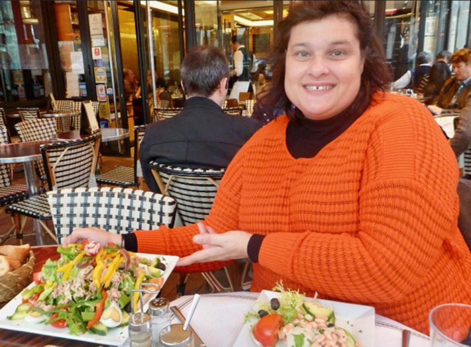 A photo of Sydney woman Maria wearing an orange jumper at a restaurant