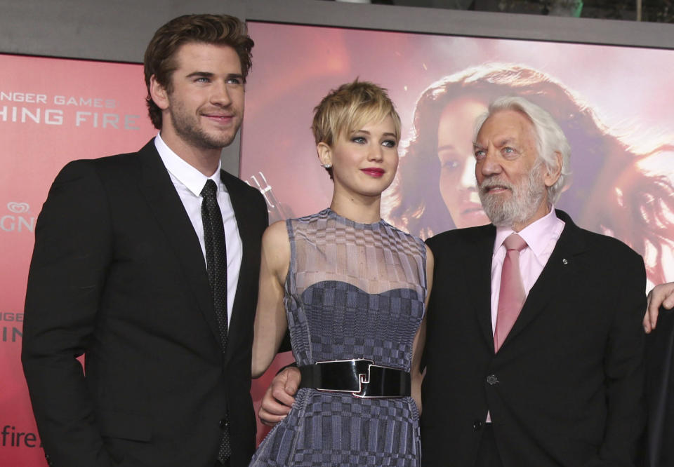 FILE - Liam Hemsworth, from left, Jennifer Lawrence and Donald Sutherland appear at the premiere of "The Hunger Games: Catching Fire" in Los Angeles on Nov. 18, 2013. Sutherland, the towering Canadian actor whose career spanned "M.A.S.H." to "The Hunger Games," has died at 88. (Photo by Matt Sayles/Invision/AP, File)