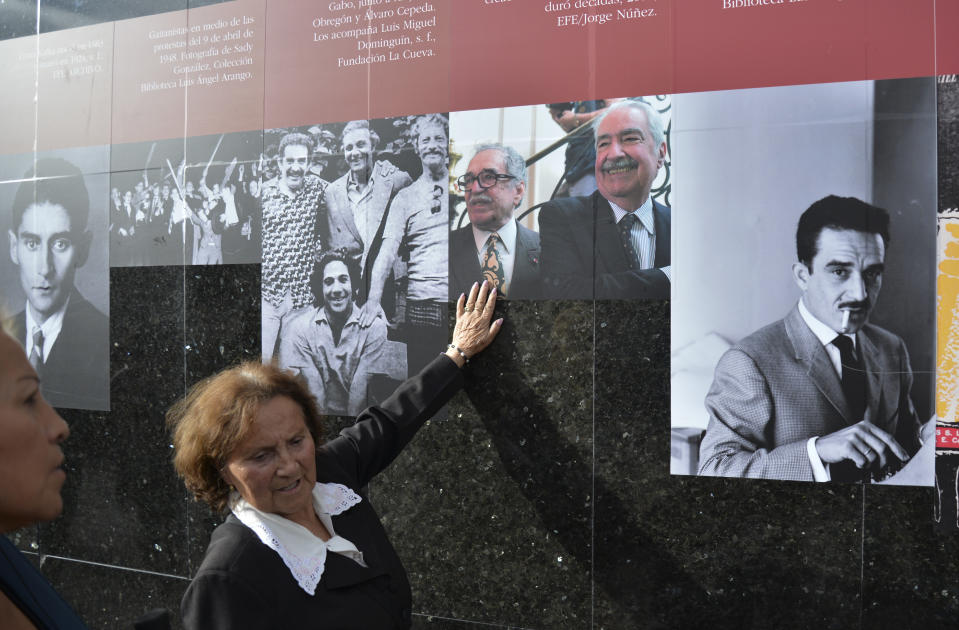 A woman touches photos on a timeline of the life of Colombian Nobel laureate Gabriel Garcia Marquez on a wall at the Luis Angel Arango Library in downtown Bogota, Colombia, Thursday, April 17, 2014. Garcia Marquez died in Mexico City on Thursday. The author was among Latin America's most popular writers and widely considered the father of a literary style known as magic realism. (AP Photo/Diana Sanchez)