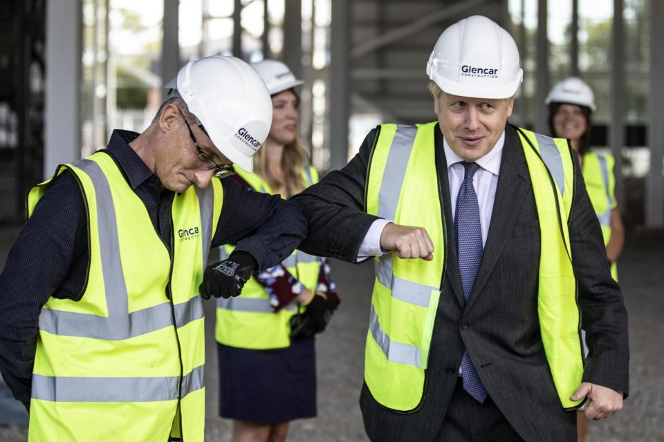 Boris Johnson bumps elbows with scientists as he visits the construction site of the new vaccines Manufacturing and Innovation Centre (PA)