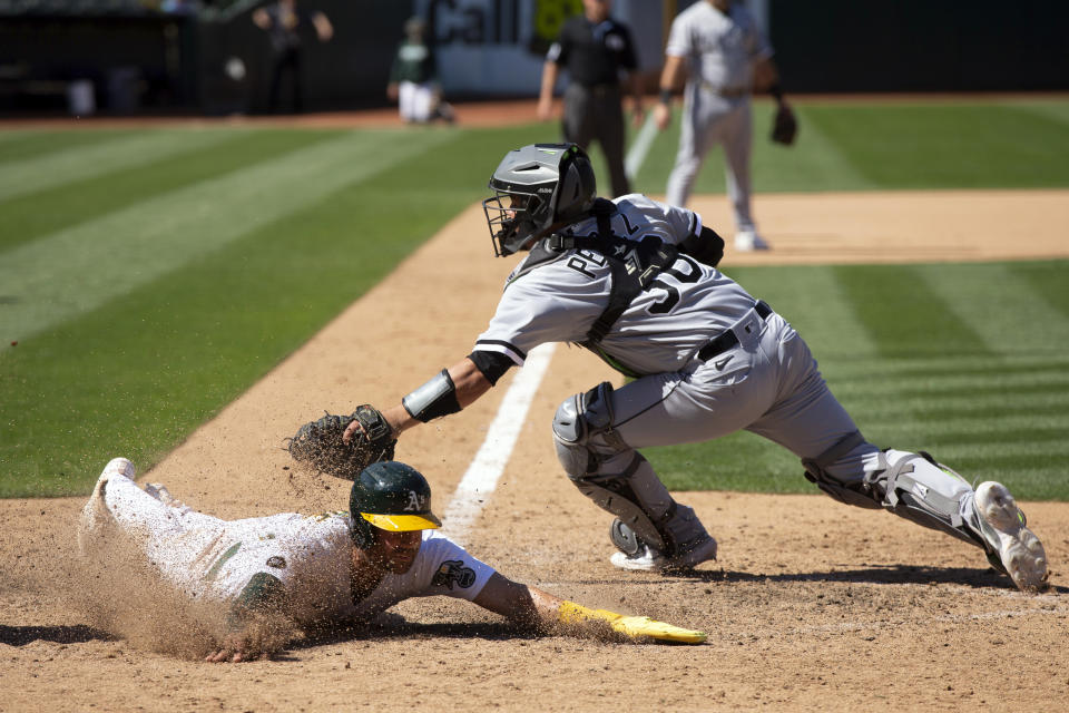 Oakland Athletics' Tyler Wade, left, slides safely across home plate with the winning run ahead of the tag by Chicago White Sox catcher Carlos Pérez (36) during the tenth inning of a baseball game, Saturday, July 1, 2023, in Oakland, Calif. The A's won 7-6. (AP Photo/D. Ross Cameron)
