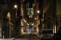 An Italian Carabinieri paramilitary police car patrols an empty street leading to the Spanish Steps and Trinita' dei Monti Church Rome, early Monday, Oct. 26, 2020. Since midnight last Friday and for the next 30 days, people in Lazio are not allowed to leave their homes from midnight to 5 a.m. daily, except to go to or return from work or for other urgent reasons such as health issues. (AP Photo/Alessandra Tarantino)