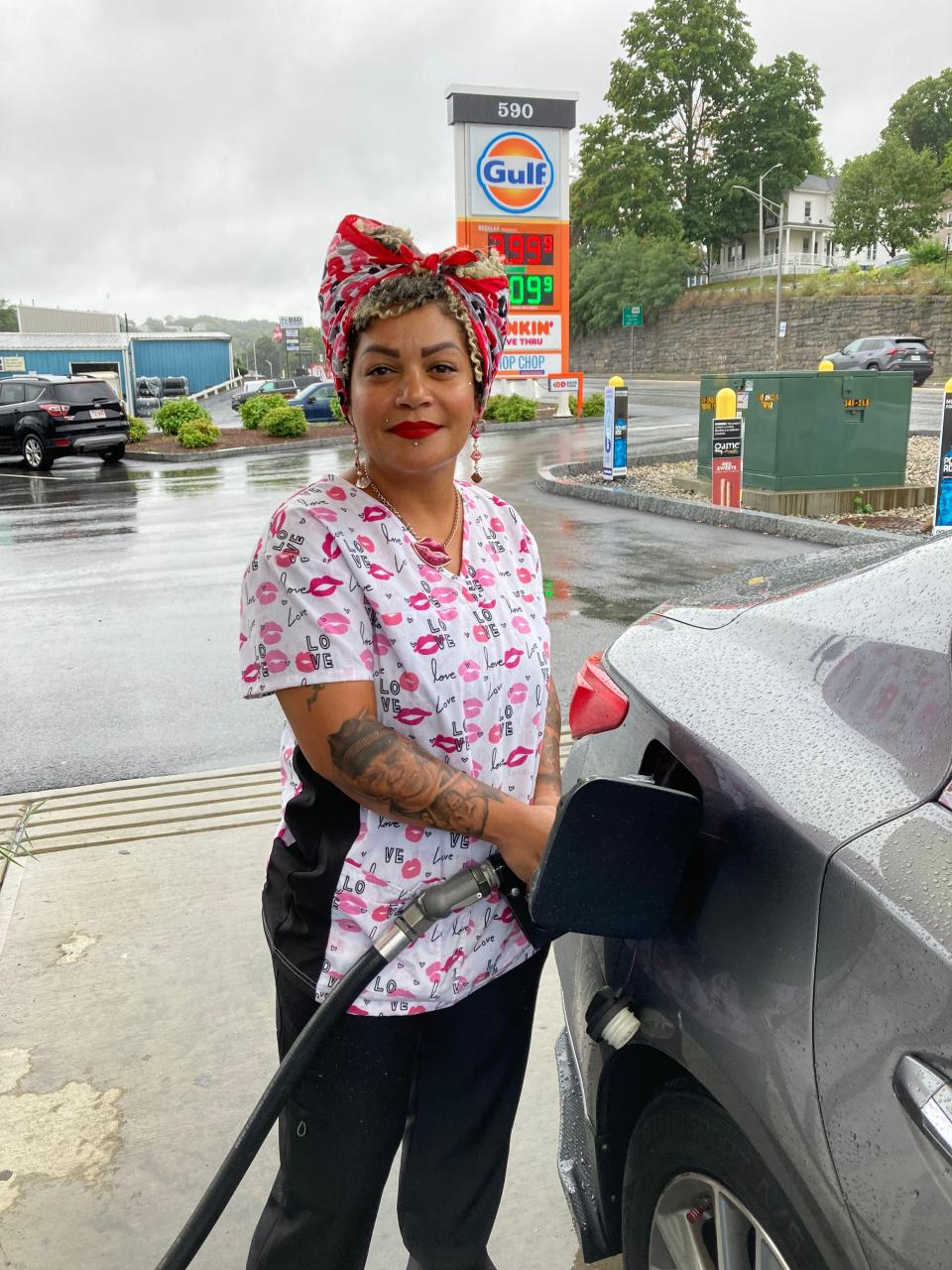Leslian Leon of Worcester filled up her gas tank during Tuesday's rainstorm.