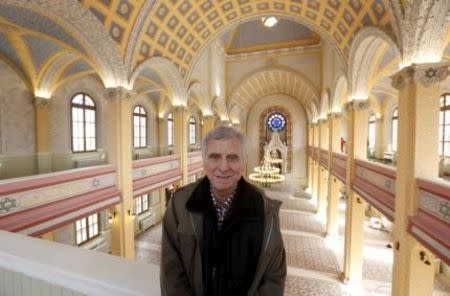 Rifat Mitrani, the town's last Jew, poses at the Great Synagogue as he visits during its restoration in Edirne, western Turkey, February 26, 2015. When the domes of Edirne's abandoned Great Synagogue caved in, Mitrani knew it spelled the end of nearly two millennia of Jewish heritage in this Turkish town. As a boy, he studied Hebrew in the synagogue's gardens and, in the 1970s, dispatched its Torah to Istanbul after the community shrank to just three families. In 1975, he unlocked its doors and swept away the cobwebs to marry his wife Sara.Now a five-year, $2.5 million government project has restored the synagogue's lead-clad domes and resplendent interior ahead of its Thursday re-opening, the first temple to open in Turkey in two generations, but one without worshippers. It is part of a relaxation of curbs on religious minorities ushered in during President Tayyip Erdogan's 12 years in power. Yet it coincides with a spike in anti-Semitism in predominantly Muslim Turkey and a wave of Jews moving away, say members of the aging community, which has shrunk by more than a third in the last quarter century.Picture taken February 26, 2015. REUTERS/Murad Sezer
