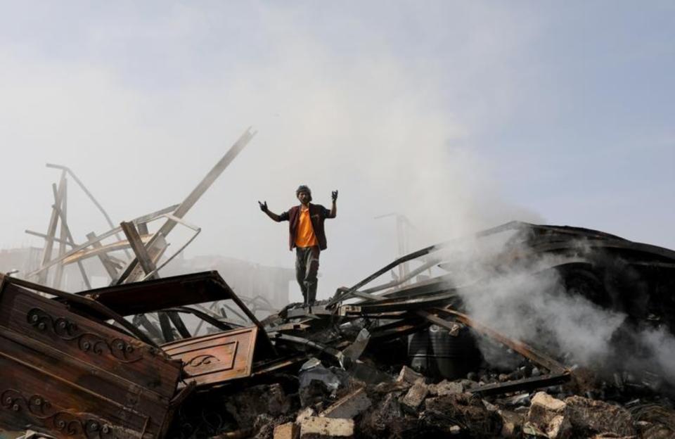 Un hombre reacciona al ver los restos de una tienda de repuestos de vehículos que ha quedado derribada tras un ataque aéreo de Arabia Saudí en Saná (Yemen). Imagen tomada el 2 de julio. (Foto: Khaled Abdullah / Reuters).