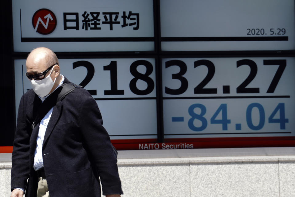 A man walks past an electronic stock board showing Japan's Nikkei 225 index at a securities firm in Tokyo Friday, May 29, 2020. Shares fell Friday in Asia after Wall Street’s rally petered out amid worries about flaring U.S.-China tensions. (AP Photo/Eugene Hoshiko)