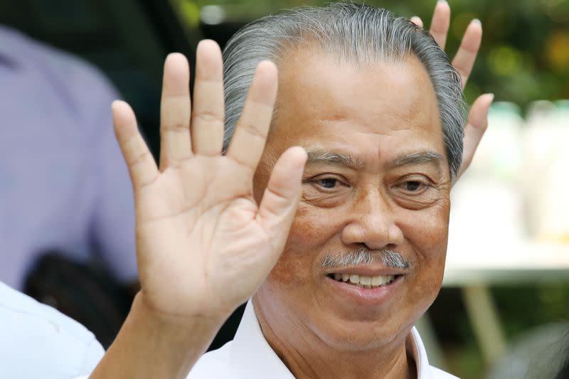 Malaysia's Prime Minister Designate and former interior minister Muhyiddin Yassin waves to reporters outside his residence in Kuala Lumpur