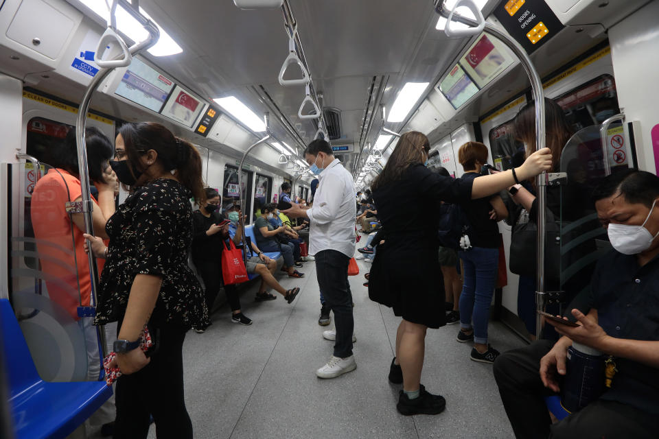 Commuters wearing protective mask ride the train on September 8, 2021 in Singapore.  (Photo by Suhaimi Abdullah/NurPhoto via Getty Images)