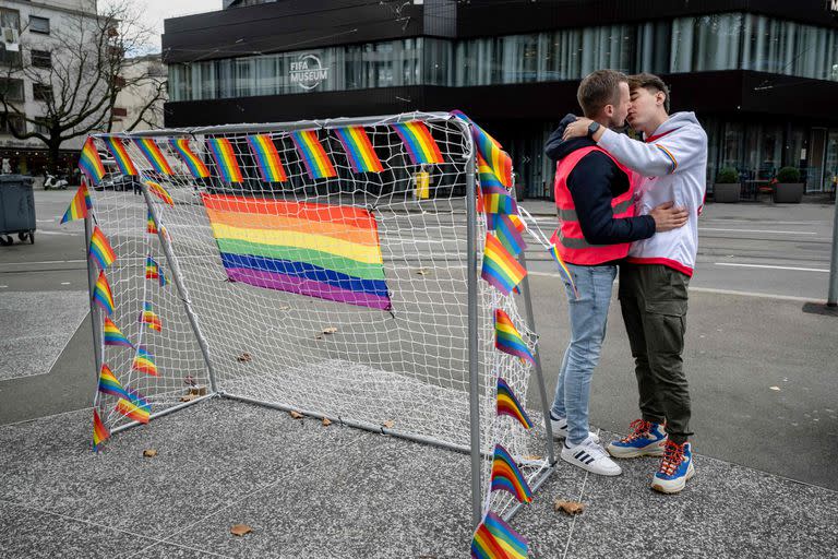 Dos hombres se besan junto a un arco de fútbol durante una acción simbólica de asociaciones LGBT+ frente al museo de la FIFA en Zúrich, el 8 de noviembre de 2022, para pedir a la FIFA que defienda los derechos de la comunidad LGBT+ antes de la Copa Mundial en Qatar 2022