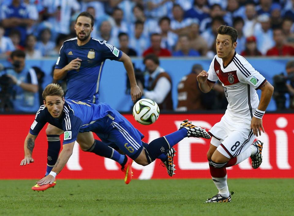 Germany's Mesut Ozil (R) fights for the ball with Argentina's Lucas Biglia (front) and Enzo Perez during their 2014 World Cup final at the Maracana stadium in Rio de Janeiro July 13, 2014. REUTERS/Darren Staples (BRAZIL - Tags: SOCCER SPORT WORLD CUP)