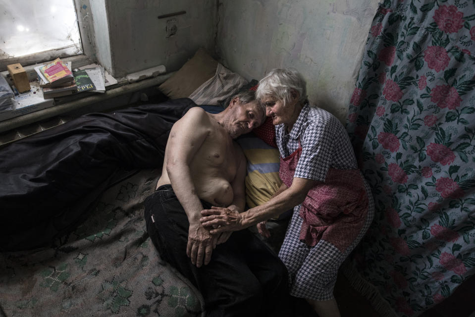 <span class="s1">Raisa Petrovna and her husband, Stanislav Vasilyevich, live in the village of Opytne, which is often caught in the crossfire between Ukrainian and pro-Russian separatists. Raisa, age 80, says that tanks were driving in front of their home in the first year of the war, and they have learned to live with the sound of shelling and gunfire daily. <i>“We were sitting at home, screaming at them not to kill us!”</i> Riasa said. Her husband was injured twice by shrapnel, once in his abdomen, requiring surgery. He has a hernia that keeps on growing, and he suffers from dementia. <i>“I have to treat him as a child, I am so sorry that he is like this now, I am afraid to leave him even for a moment,” </i>Raisa says. Their two sons live on the other side of the contact line, unable to visit often because of the war. (Photograph by Paula Bronstein)</span>