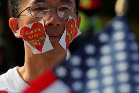 A man wearing stickers on his face attends the "Rally for the American Dream - Equal Education Rights for All," ahead of the start of the trial in a lawsuit accusing Harvard University of discriminating against Asian-American applicants, in Boston, October 14, 2018. REUTERS/Brian Snyder