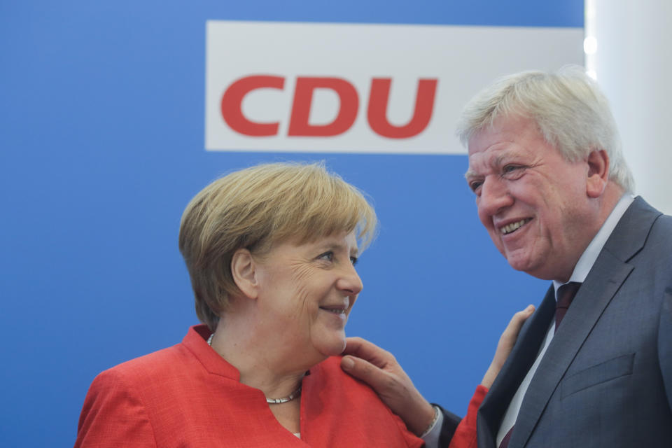 FILE - In this June 18, 2018 file photo German Chancellor Angela Merkel, left, talks with the Prime Minister of the Hesse state Volker Bouffier, right, prior to leaders meetings of her Christion Democratic Union party at the party's headquarters in Berlin. The stakes are unusually high for German Chancellor Angela Merkel’s government as the central region of Hesse votes in a state election this weekend. (AP Photo/Markus Schreiber, file)